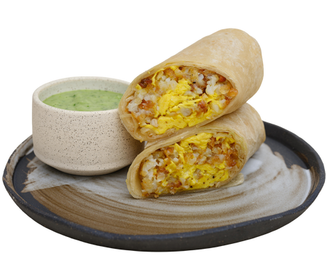 Two burritos stacked on a plate with a bowl of guacamole on a white background